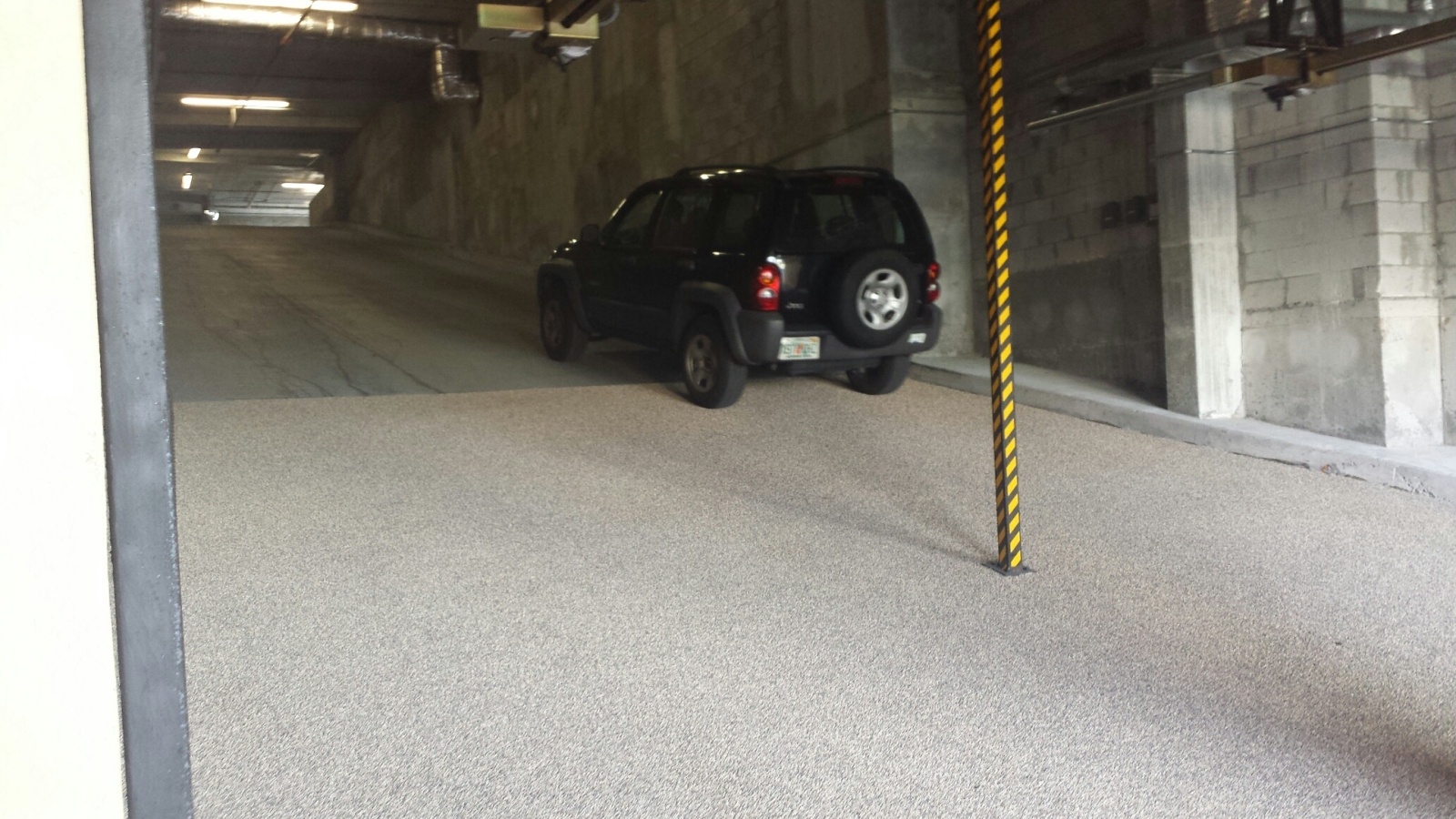 black SUV driving up a Steep Grade parking garage